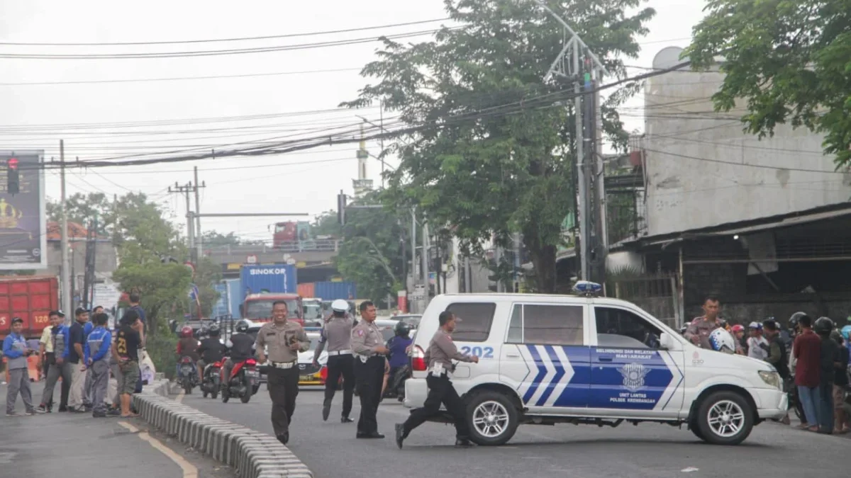 Sejumlah petugas keamanan tampak berusaha membuat situasi tetap kondusif, termasuk menenangkan warga sekitar.