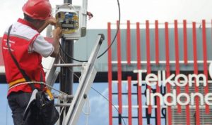 Seorang petugas dari PT Telkom sedang memperbaiki jaringan kabel