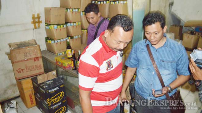 INUMAN BERBAHAYA: Polisi Polres Bandung menunjukkan jamu bodong dan minuman keras yang berhasil disita dari sebuah gudang di Kampung Pasar Desa, Jalan BAru Raya, Desa Cangkuan Kulon, Dayeuhkolot, Kabupaten Bandung Kamis malam (2/7).