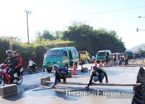 Kesiapan Jalur Mudik 70 Persen AMRI RACHMAN DZULFIKRI/BANDUNG EKSPRES LAKUKAN PERSIAPAN: Sejumlah kendaraan melintasi satu ruas jalan di Jalan Raya Nagreg, Kabupaten Bandung, Jumat (12/6). Jalan tersebut diperbaiki untuk persiapan kelancaran arus mudik 2015 bulan depan.