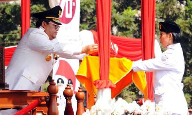 SERAHKAN BENDERA: Gubernur Jabar Ahmad Heryawan mengambil bendera dari anggota Paskibraka dalam upacara peringatan kemerdekaan, Senin (17/8). Heryawan meminta agar Indonesia tidak tergantung bangsa lain ke depannya.