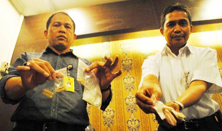 TUNJUKAN BARANG BUKTI: Kasubdit II AKBP Nugroho Arianto (kiri) menunjukkan barang bukti pil ekstasi dan sabu saat gelar perkara kasus penyalahgunaan narkotika di Mapolda Jabar, jalan Soekarno-Hatta, Kota Bandung, Selasa (11/8).