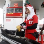 LAYANI SENYUM: Petugas SPBU mengisi bensin ke sepeda motor. Pemerintah ngotot Dana Ketahanan Energi dipungut tahun depan.
