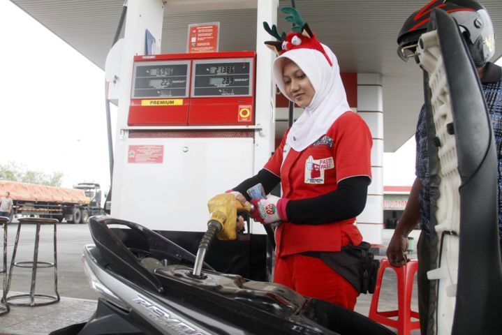 LAYANI SENYUM: Petugas SPBU mengisi bensin ke sepeda motor. Pemerintah ngotot Dana Ketahanan Energi dipungut tahun depan.
