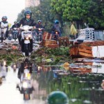 Pengendara bermotor menghundari tumpukan barang dagangan yang rusak akibat banjir di Pasar Gedebage, Jalan Soekarno-Hatta, Kota Bandung, Rabu (8/6).