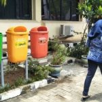 Seorang PNS berjalan di depan tempat pembuangan sampah tiga jenis di lingkungan perkantoran Pemkot Bandung.