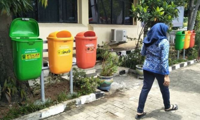 Kelola Sampah dari Rumah Tangga Seorang PNS berjalan di depan tempat pembuangan sampah tiga jenis di lingkungan perkantoran Pemkot Bandung.