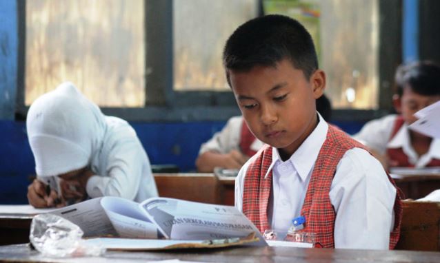 Seorang siswa Sekolah Dasar (SD) kelas 6 tengah fokus membaca soal USBN pada tahun lalu, untuk dipahami sekaligus di isi dengan jawaban yang benar.