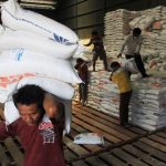 Petugas gudang Bulog sedang memindahkan beras dari gudang ke dalam truk untuk didistribusikan ke daerah dalam bentuk bantuan.