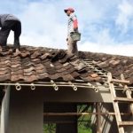 BENAHI ATAP : Dua orang warga ikut membantu membenahi atap pada program bantuan untuk rumah tidak layak huni (Rutilahu). (ILUSTRASI)