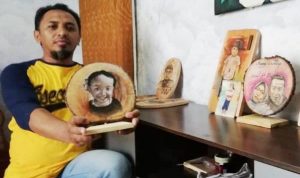 Dani Suhendar saat menunjukkan hasil karyanya berupa lukisan dari limbah kayu yang bernilai ekonomis.