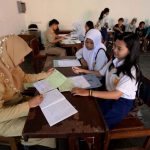 PERIKSA BERKAS: Seorang guru di salah satu SMAN Kota Bandung saat memeriksa berkas siswa yang mendaftar PPDB. (ist)