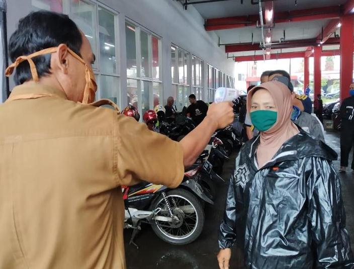 ILUSTRASI :Petugas dari UPTD Pasar memeriksa suhu pengunjung sebelum memasuki area Pasar Atas Baru. Pengecekan tersebut sebagai salah satu upaya Pemkot Cimahi, mencegah penularan virus korona di Cimahi.