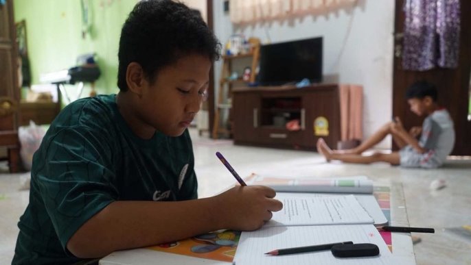 siswa tampak fokus mengerjakan tugas sekolah di rumah selama libur sekolah akibat pandemi Covid-19.