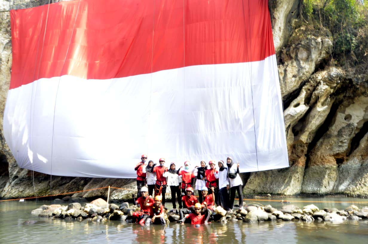 Bendera Merah Putih Raksasa Membentang di Tebing Purbakala Sanghyang Kenit