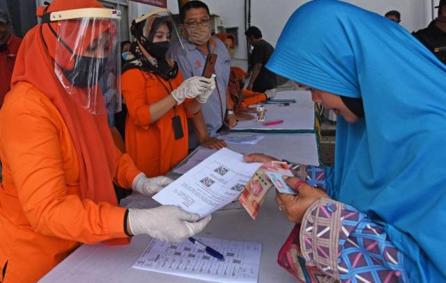 Petugas PT Pos saat menyalurkan bansos kepada warga yang berhak menerima di tengah wabah virus korona beberapa waktu lalu.