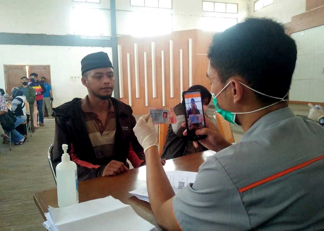 Petugas dari PT POS sedang memeriksa KTP milik warga (Ilustrasi/Dok Jabarekspres.com)