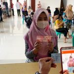 TERIMA BANTUAN: Seorang petugas saat mengambil gambar sebagai bukti penyerahan bantuan bagi warga terdampak korona. (ILUSTRASI)