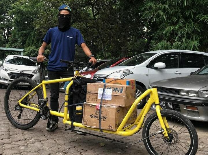 Musim Penghujan Tak Surutkan Semangat Kurir Sepeda Berikan Layanan