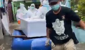 Anggota Polisi Ini, Makamkan Jenazah Pasien Covid-19 di Tengah Banjir Anggota Polisi Ini, Makamkan Jenazah Pasien Covid-19 di Tengah Banjir