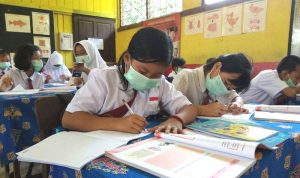ILUSTRASI PTM: Sejumlah siswa tampak serius saat belajar di ruang kelas dengan tetap memakai masker sebagai upaya menekan sebaran Covid-19.
