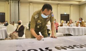 Penyerapan Anggaran Pemkot Cimahi Semester Pertama Baru 15 Persen Pelaksana Tugas (Plt.) Wali Kota Cimahi, Ngatiyana lakukan tanda tangan pada sebuah spanduk putih sebagai bentuk partisipan dalam acara rembuk stunting Kota Cimahi, Mason Pine Hotel, Padalarang, Senin (31/5). (Intan Aida/Jabar Ekspres)