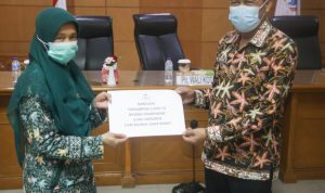 Pelaksana Tugas (Plt.) Wali Kota Cimahi, Ngatiyana memberikan simbolis bantuan pada salah satu guru honorer, Aula Gedung A Pemkot Cimahi, Kamis (10/6). (Intan Aida/Jabar Ekspres)