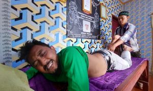 PENGOBATAN TRADISIONAL: Paranormal sekaligus tukang pijat tradisional di KBB saat melakukan praktiknya pada seorang warga. (Wisnu/Jabar Ekspres)