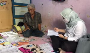 BERTUGAS: Seorang tenaga pekerja sosial (Peksos) tengah menjalankan tugasnya.