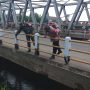 Petugas Polisi dan TNI sedang mengecek badan jembatan yang mengalami keretakan