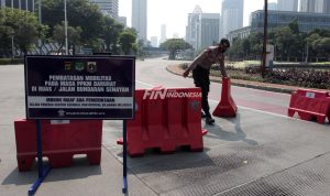 Anggota Kepolisi memberhentikan pengendara yang ingin melintas jalan Sudirman saat berlangsungnya Pemberlakuan Pembatasan Kegiatan Masyarakat (PPKM) Darurat di kawasan Bundaran Senayan, Jakarta, Sabtu (3/7). Mulai hari ini pemerintah melakukan PPKM Darurat di sejumlah daerah sebagai upaya memutus rantai penyebaran Covid-19 yang terus meningkat. (Issak Ramdhani / fin.co.id)