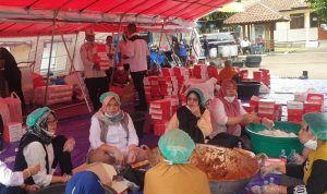 Menteri Sosial Tri Rismahariani terjun langsung untuk melihat dan membantu penyiapan nasi kotak untuk didistribusikan.