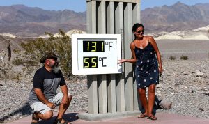 Wisatawan menunjukan suhu di Taman Nasional Death Valley pada yang mencapai suhu terpanas yang tercatat di Bumi setidaknya sejak 1913, (Foto: Mario Tama/Getty Images)