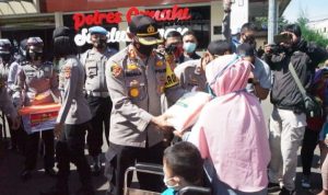 Selama PPKM Darurat, Polres Cimahi Bagikan Paket 500 Sembako Kapolres Cimahi, AKBP Indra Setiawan membagikan paket sembako pada salah satu warga di Mapolres Cimahi, Minggu (11/7).