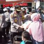 Kapolres Cimahi, AKBP Indra Setiawan membagikan paket sembako pada salah satu warga di Mapolres Cimahi, Minggu (11/7).