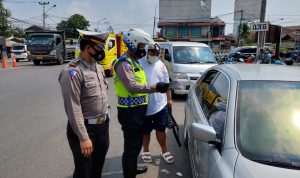 Petugas Satlantas Polres Cimahi memeriksa surat dari pengendara dari luar KBB.