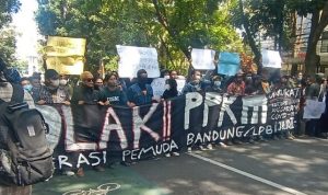 Para demonstran membentangkan banner bertuliskan penolakan terhadap diperpanjangnya PPKM Darurat.