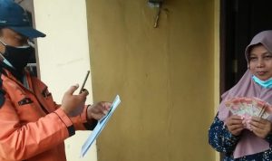 Salah seorang KPM saat menerima dana BST melalui petugas Kantor Pos Kota Depok