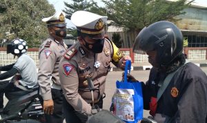 Kasat Lantas Polres Sumedang, AKP Eryda Kusumah saat berikan paket sembako di pos penyekatan Unpad Jatinangor, Jumat (23/7). (Yanuar Baswata/Jabar Ekspres)
