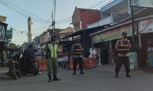 Polisi dan Linmas bekerjasama menjaga penyekatan di Jalan Haji Darham, akses jalan menuju Alun-alun Cicalengka, Senin (26/7). (Yanuar Baswata/Jabar Ekspres)