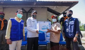 Salah seorang penggali lahan makam covid-19 menerima bantuan dari Pemkot Cimahi melalui lembaga Rumah Yatim dan salah satu relawan dari Program Jabar Quick Response, TPU Kihapit Cimahi, Rabu (28/7). (Intan Aida/Jabar Ekspres)