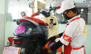 Perawatan motor Mekanik sepeda motor Honda mengganti oli mesin sepeda motor milik konsumen yang sedang servis di bengkel resmi Honda atau AHASS