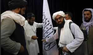 Kaum LGBT di Afganistan Terancam Hukuman dari Taliban Pejabat Taliban mengatur bendera Taliban, sebelum konferensi pers oleh juru bicara Zabihullah Mujahid di Pusat Informasi Media Pemerintah, Kabul, Afghanistan, Selasa (17/8). Foto: Rahmat Gul/AP Photo