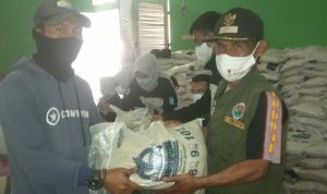Alhamdulillah, 833 Warga Desa Waluya Tercatat Tertima Bansos dari Kemensos Kepala Desa Waluya, Aa Suryana (kanan) saat memberikan bantuan paket beras dari Kemensos kepada warga.