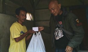 Jurnalis saat memberikan bantuan kepada korban longsor Sumedang, Rismana, 33, di kediamannya pada Rabu (4/8).