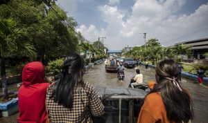 Warga menumpang mobil bak saat melintasi banjir rob di kawasan Pelabuhan Perikanan Muara Baru, Jakarta, Jumat (28/5/2021). ANTARA FOTO/Dhemas Reviyanto/foc.
