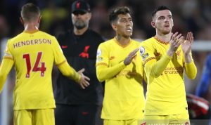 Belum Cicipi Kekalahan, Liverpool Pemuncak Klasemen Sementara Liga Inggris Bek Liverpool Andy Robertson (kanan) dan penyerang Roberto Firmino bertepuk tangan mengucapkan terima kasih kepada suporter tandang setelah bermain imbang melawan Brentford di Stadion Brentford Community, London, Inggris, Sabtu (25/9/2021) waktu setempat. (ANTARA/REUTERS/ACTION IMAGES/Matthew Childs)