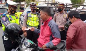 Sejumlah personel polisi membagikan masker kepada pengendara sepeda motor di Jalan Bunderan Suci, Kabupaten Garut, Jawa Barat, Senin (20/9/2021). (ANTARA/Feri Purnama)