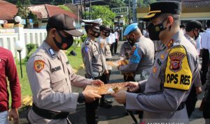 Kapolres Sukabumi Kota AKBP Zainal Abidin saat memberikan reward kepada salah satu personelnya yang telah berhasil mengungkap berbagai kasus kriminal di Kota Sukabumi, Jabar pada Senin, (27/9) di halaman Mapolres Sukabumi Kota. (Antara/Aditya Rohman)