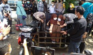 Polisi membantu putri kembar siam untuk menggunakan kursi roda dan sepeda motor yang sudah dimodifikasi di Karangpawitan, Kabupaten Garut, Jawa Barat, Jumat (3/9/2021). (ANTARA/Feri Purnama)
